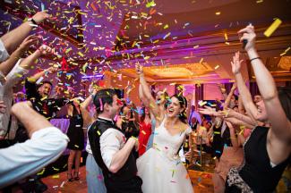 Bride & Groom laughing with colourful confetti thrown into the air
